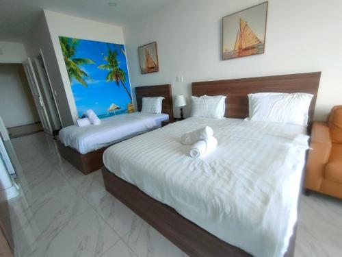 a bedroom with two beds with white sheets and a window at Hotel,Căn Hộ Mũi Né Sea link in Phan Thiet