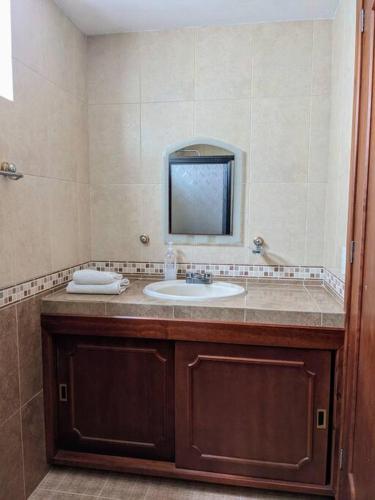 a bathroom with a sink and a mirror at Casa Mua in San Cristóbal de Las Casas