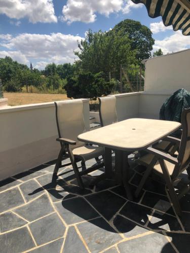 a wooden table and two chairs on a patio at LE GRILLOU in Couterne