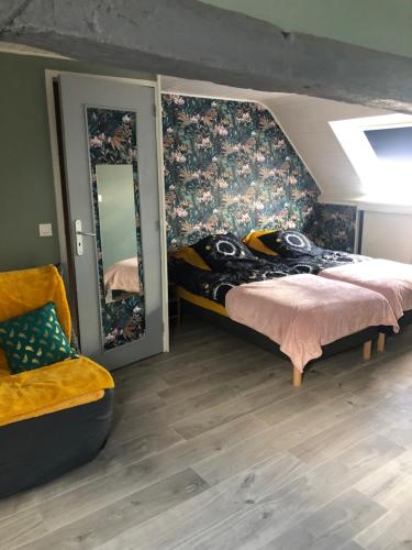 1 dormitorio con cama, silla y espejos en LE GRILLOU, 