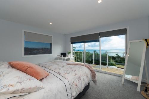 1 dormitorio con cama y ventana grande en Luxury Lookout - Cable Bay Holiday Home en Cable Bay