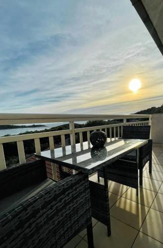 a table on a balcony with a view of the ocean at B&B Paradiso - Pakleni Islands Hvar in Hvar
