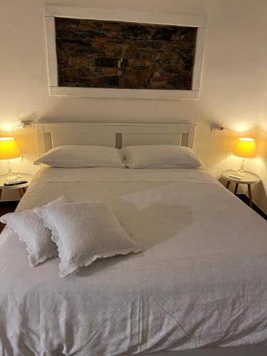 a bedroom with a white bed with two lamps at Golfo Dei Poeti Apartment in Lerici