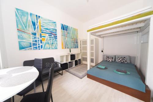 ブダペストにあるCosy studio apartment with AirConditionerのベッドとダイニングテーブル付きの小さな部屋です。