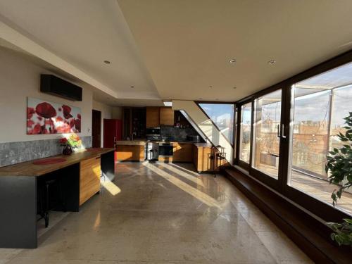 eine große Küche mit großen Fenstern und Stadtblick in der Unterkunft Spacious apartment with shared jacuzzi/private terrace in Budapest