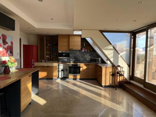 eine große Küche mit Holzschränken und einem großen Fenster in der Unterkunft Spacious apartment with shared jacuzzi/private terrace in Budapest