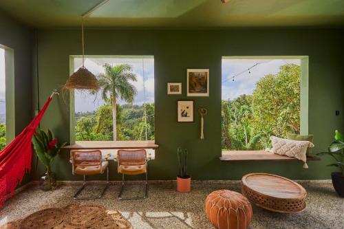 a room with a green wall with a hammock in it at WALD HAUS by DW in Naguabo
