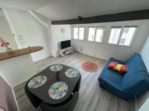 a living room with a blue couch and a table at Appartement Calais Nord in Calais