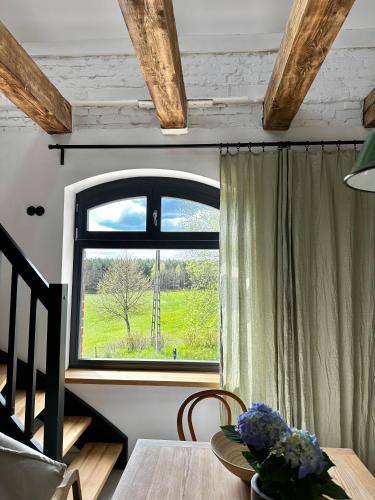 a dining room with a table and a window at Ublik Stacja in Ublik