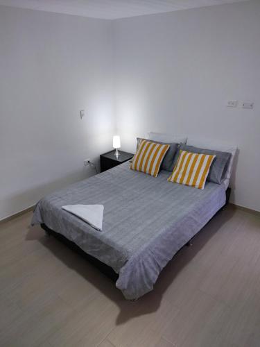 a bedroom with a large bed with two pillows at El Rincón de Granada Casa de Huespedes in Cali