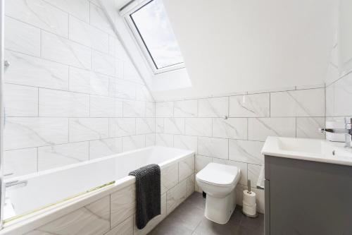 La salle de bains est pourvue d'une baignoire, de toilettes et d'un lavabo. dans l'établissement Spacious, newly renovated, three bedroom TOWN CENTRE duplex apartment with free parking, sleeps seven - Walking distance to beach, à Bournemouth