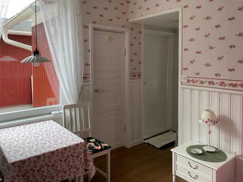 Habitación pequeña con cama, mesa y espejo. en Strandbergs Stugor, en Mariehamn