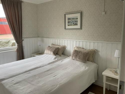 a bedroom with a white bed and a window at Strandbergs Stugor in Mariehamn
