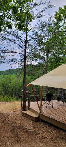 a wooden deck with a large tent and a chair at Mountain Tent Beautiful Tranquil Inspiring Tent 2 in Lenoir