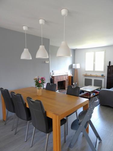 une salle à manger avec une table et des chaises en bois dans l'établissement Chambre et salle de bain de privée proche de Pau, à Bizanos