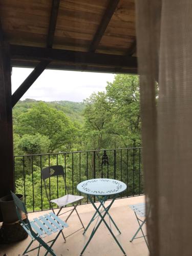 eine Terrasse mit einem Tisch und 2 Stühlen auf einem Balkon in der Unterkunft Château de Bataillé in Figeac