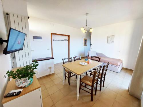 - un salon avec une table à manger et un canapé dans l'établissement Mini Appartamenti Elba, à Lacona