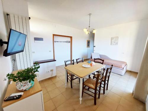 sala de estar con mesa de comedor y sofá en Mini Appartamenti Elba, en Lacona