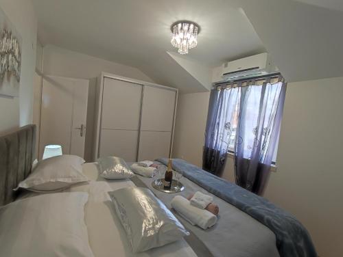 a bedroom with a large white bed with pillows at Apartman Oaza - Ploče, Croatia in Ploče