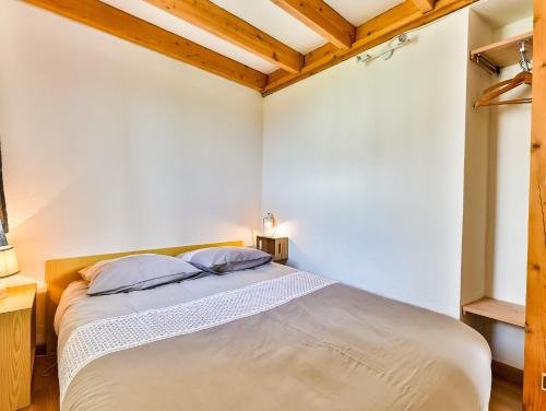 - une chambre avec un lit doté de draps blancs et de plafonds en bois dans l'établissement Vif océan, à Saint-Hilaire-de-Riez