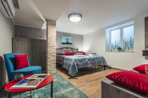 a bedroom with a bed with red pillows at Capitans House in Šibenik