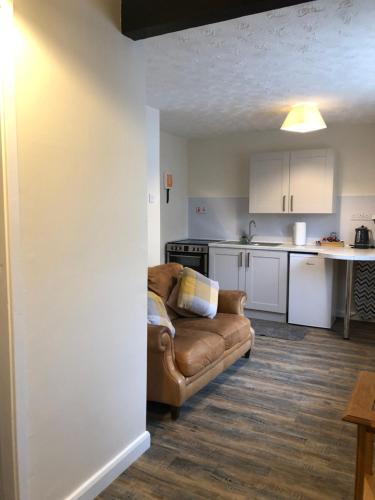 a living room with a couch and a kitchen at Little Park Holiday Homes Self Catering Cottages 1 & 2 bedrooms available close to Tutbury Castle in Tutbury