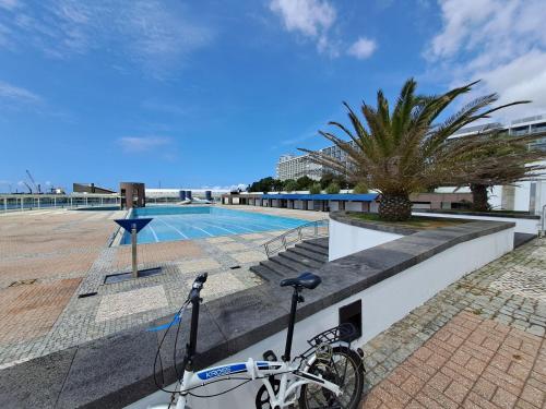 a bike parked next to a swimming pool at SolMar View Apartment, Azores in Ponta Delgada