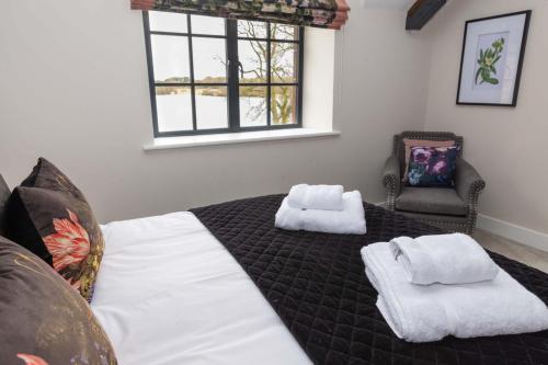a bedroom with a bed with towels on it at Tarn End Cottage with view to Talkin Tarn, near Lake District in Brampton