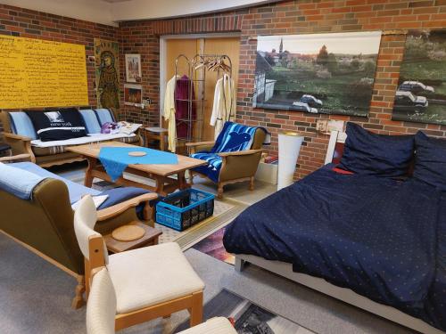 sypialnia z łóżkiem i krzesłami oraz ceglaną ścianą w obiekcie Station im Norden w mieście Bindslev