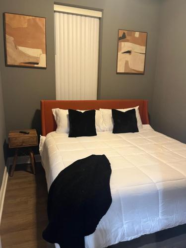 1 dormitorio con 1 cama grande con sábanas blancas y almohadas negras en Rustic Mix en Chicago
