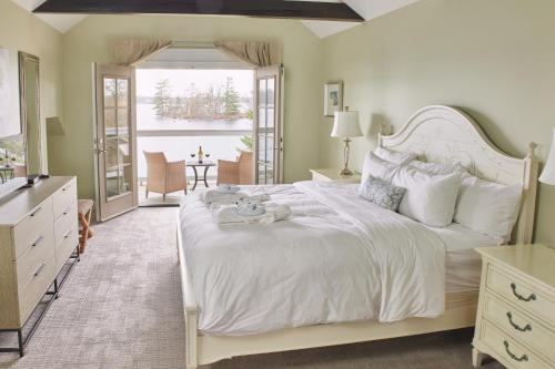 a bedroom with a white bed with a teddy bear on it at Rawley Resort, Spa & Marina in Port Severn