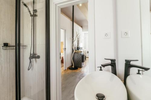 La salle de bains est pourvue d'un lavabo blanc et d'un miroir. dans l'établissement Casa do Baloiço, à Cortes do Meio