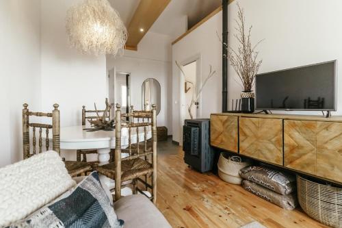 a living room with a couch and a tv at Casa do Baloiço in Cortes do Meio