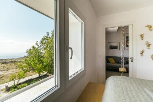 1 dormitorio con ventana y vistas al desierto en Casa do Baloiço, en Cortes do Meio