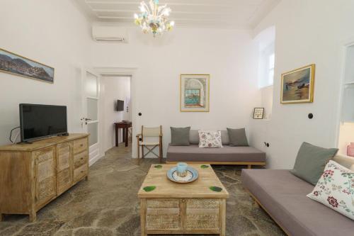 a living room with a couch and a tv at Livin Hydra Private Collection Suite 1 in Hydra