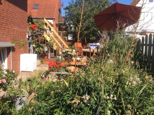 um jardim com uma mesa e um guarda-sol em Schwalbennest_ Silke Felix em Sierksdorf