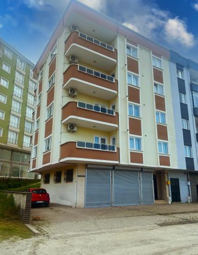 um prédio de apartamentos com um carro estacionado em frente em Seabird Suite Apart Hotel em Trabzon