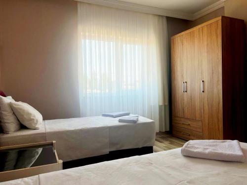 a bedroom with two beds and a wooden cabinet at Seabird Suite Apart Hotel in Trabzon