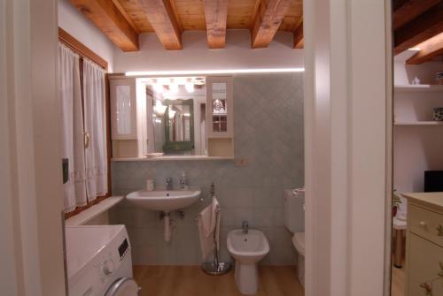 uma casa de banho com um lavatório e um WC em Ninette Home em Veneza