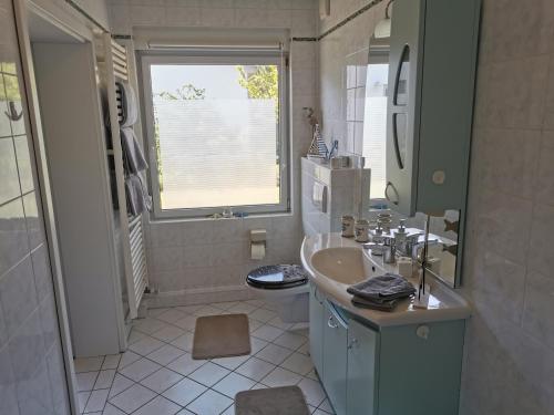 Baño blanco con lavabo y aseo en Ferienwohnung Emmi, en Malchow