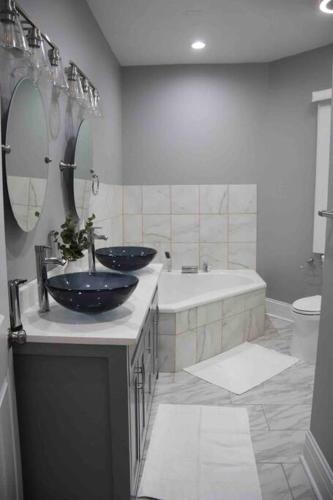 a bathroom with two sinks and a tub and a toilet at Upscale apartment Westside of Chicago in Chicago