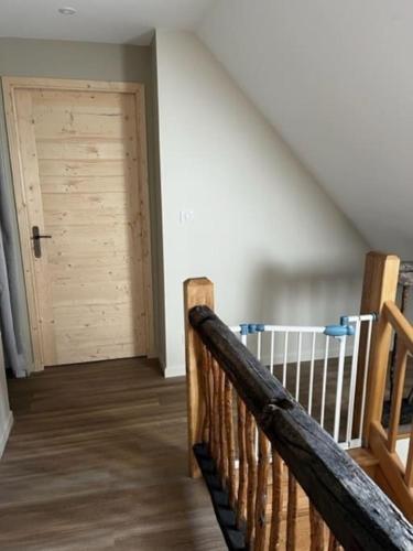 a wooden staircase with a door in a room at L’étable d’Auguste in Arreau