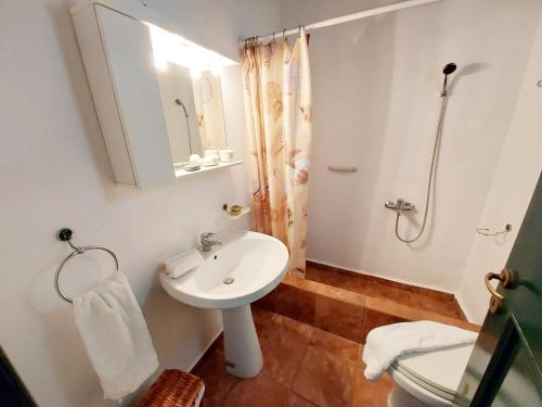 a white bathroom with a sink and a shower at Village Sense, Pergola & Unlimited View in Andros