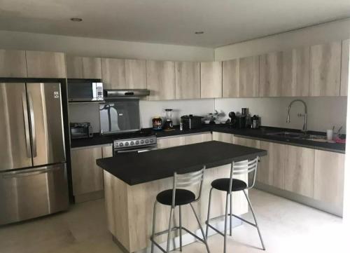 a kitchen with a counter and two bar stools at Casa Rosa in San Bartolo