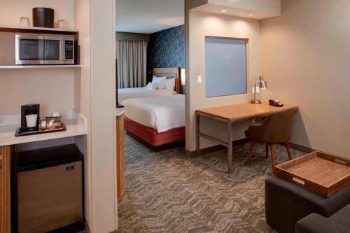 a hotel room with a bed and a desk at SpringHill Suites St. Louis Brentwood in Brentwood