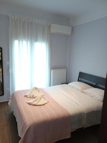 Kalamaria brand new 1 bedroom apartment في سلانيك: غرفة نوم بسرير عليها روب