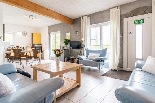 a living room with blue furniture and a table at Eifel-Apartments Orsfeld in Orsfeld