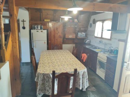 una pequeña cocina con mesa y nevera en Bungalow Villa Pehuenia en Villa Pehuenia