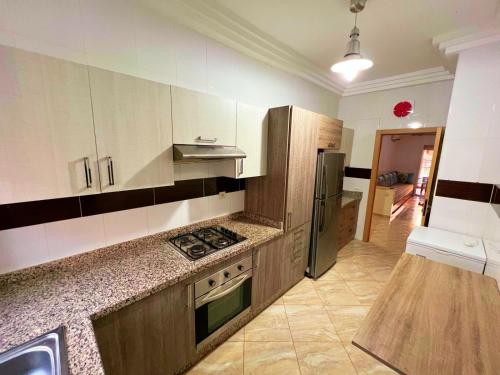a kitchen with a stove and a refrigerator at Reco flores PALM in O Ben Slimane