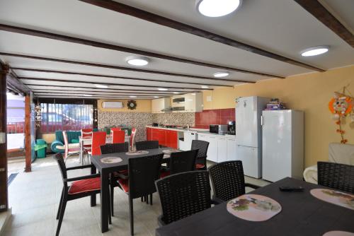ein Esszimmer mit Tischen und Stühlen sowie eine Küche in der Unterkunft Casa Octaral in Eforie Nord